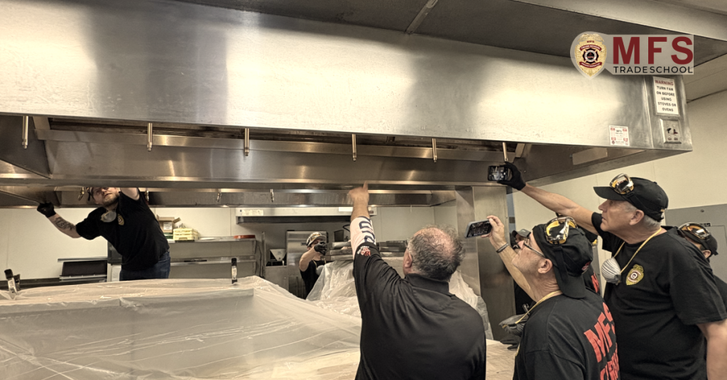 MFS Trade School students inspecting a restaurant exhaust hood system during hands-on kitchen exhaust hood cleaning certification training, learning proper inspection techniques, safety procedures, and industry best practices.